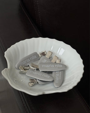 Silver hair clips in white bowl
